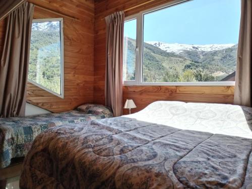 1 dormitorio con 2 camas y ventana grande en Catedral View minimo 4 noches en San Carlos de Bariloche