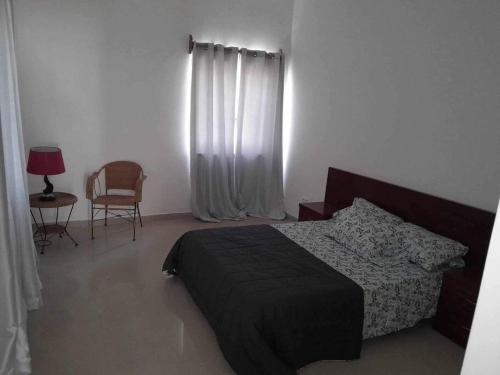 sypialnia z łóżkiem, stołem i krzesłem w obiekcie Christian’s Villa w mieście Cidade Velha