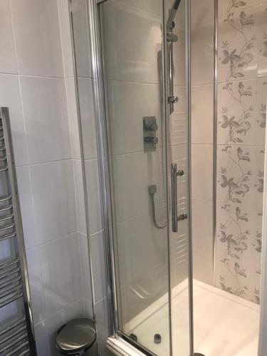 a bathroom with a shower with a glass door at Glenlyon Bed and Breakfast - NEC in Hampton in Arden