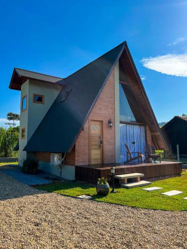 uma casa com um telhado preto numa calçada de cascalho em Chalé Villa Felicitá (Itália) em Pomerode