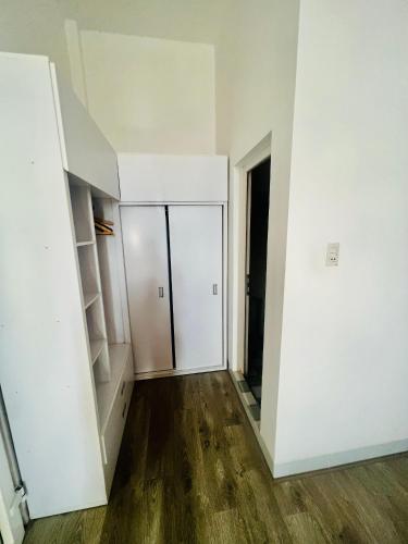 an empty room with white walls and wooden floors at D'Villa Hotel - Homestay in Kon Tum