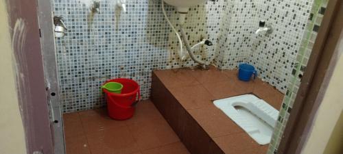 La petite salle de bains est pourvue de toilettes et d'un lavabo. dans l'établissement New Milan Palace, DEOGHAR, à Deoghar