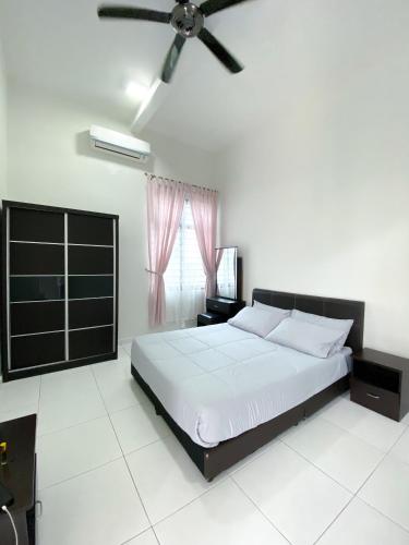 een slaapkamer met een bed en een plafondventilator bij Cosy House For Family Or Group In Bukit Beruang Melaka in Kampong Pengkalan Batu