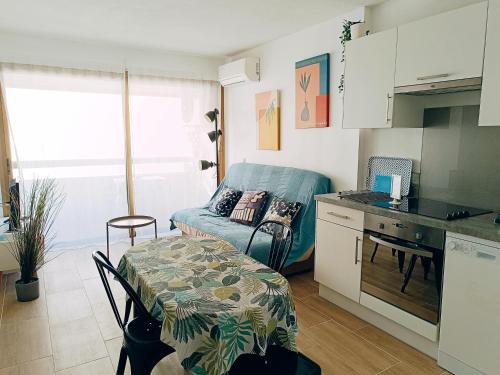 une cuisine avec une table et une petite cuisine avec un canapé dans l'établissement 2 pièces climatisé avec balcon dans le vieil Antibes, résidence avec ascenseur, à Antibes