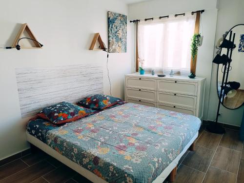a bedroom with a bed and a dresser at 2 pièces climatisé avec balcon dans le vieil Antibes, résidence avec ascenseur in Antibes