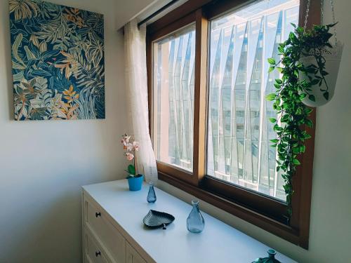 a room with a window with vases on a dresser at 2 pièces climatisé avec balcon dans le vieil Antibes, résidence avec ascenseur in Antibes