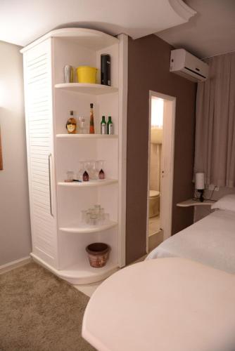 un armario blanco en un dormitorio con cama en Otimo Flat c WI-FI no centro de Santa Rosa, en Santa Rosa