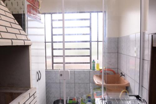 een kleine badkamer met een raam en een wastafel bij Incrivel apto completo e confortavel Santa Rosa RS in Santa Rosa