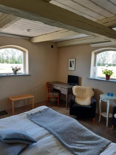 Bed & Breakfast Vinkille في Löderup: غرفة نوم بسرير ومكتب ونوافذ