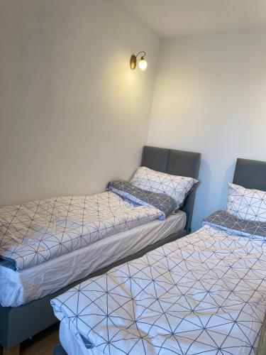 two beds sitting next to each other in a room at P15 in Suwałki