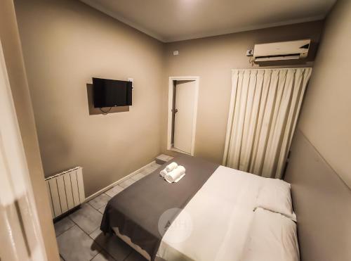 Kleines Zimmer mit einem Bett und einem TV in der Unterkunft Hotel Alhambra in San Juan