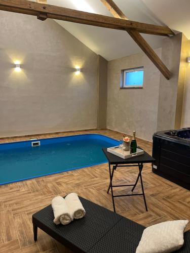 una piscina en una habitación con mesa en Wellness Tajemství Lucy, 