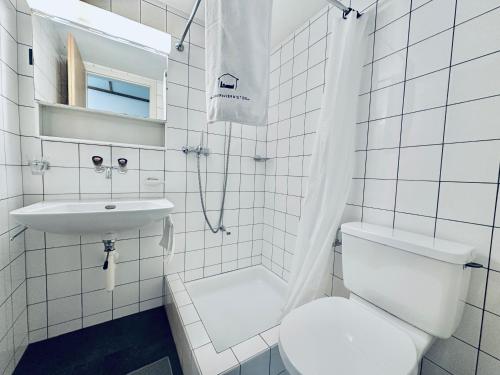 a white bathroom with a toilet and a sink at Monteurzimmer - Worker's accommodation - ZIMMERzuVERMIETEN in Bäriswil in Bäriswil