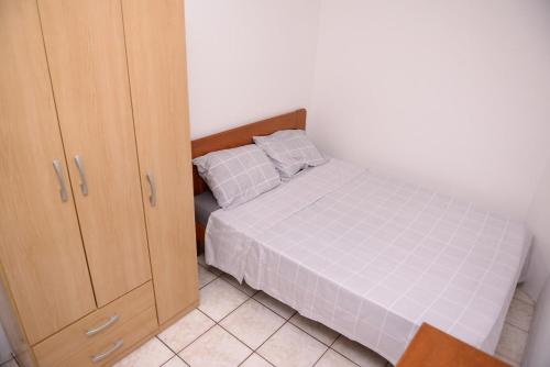 1 dormitorio con 1 cama y armario de madera en Apto c Wifi e otima localizacao em Santa Rosa RS en Santa Rosa