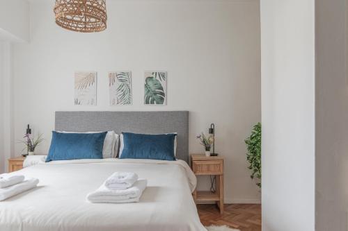 1 dormitorio con cama blanca y almohadas azules en Fliphaus Melo 2900 - 1 Bd Alto Palermo en Buenos Aires