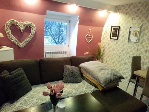 uma sala de estar com um sofá e uma janela de coração em Nowoczesne mieszkanie blisko natury i sklepu Biedronka em Karpacz