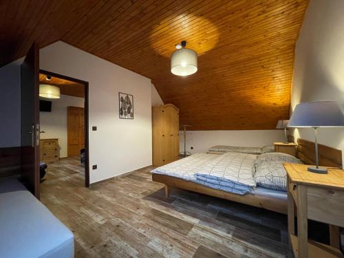 a bedroom with a bed and a wooden ceiling at Pension Polonia in Vrchlabí
