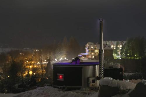 a stove with a blue top in the snow at night at PORTAL WYSOWA in Wysowa-Zdrój