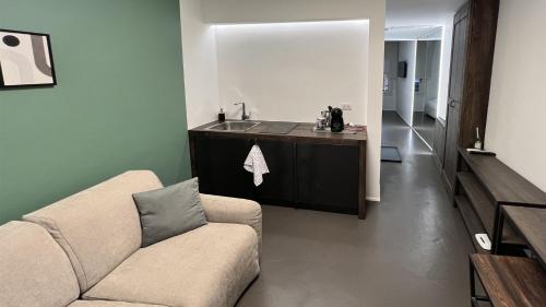 a living room with a couch and a sink at Mutina Suites in Modena