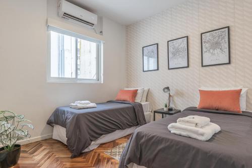 Habitación con 2 camas y toallas. en Fliphaus Esmeralda 900 - 2 Bd Calle Florida en Buenos Aires