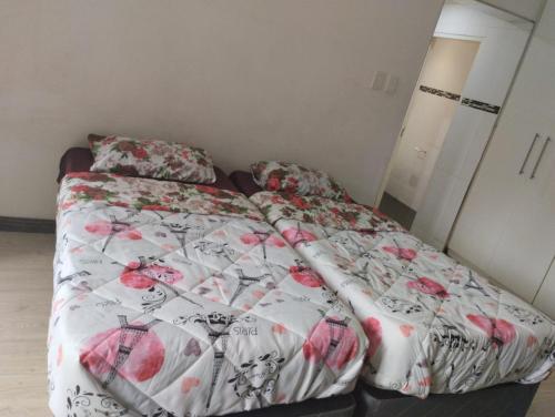 een slaapkamer met een bed met een wit en rood dekbed bij Inspire living in Benoni