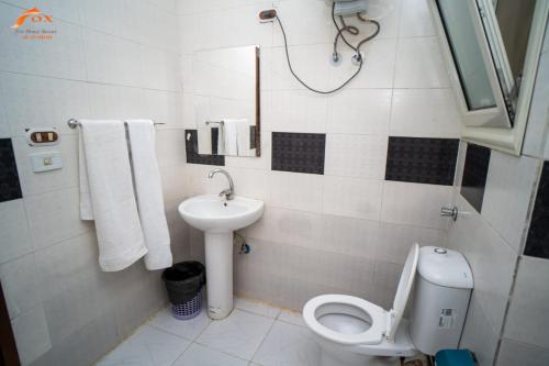La salle de bains est pourvue de toilettes et d'un lavabo. dans l'établissement ELCAPTION RESORT, à Hurghada
