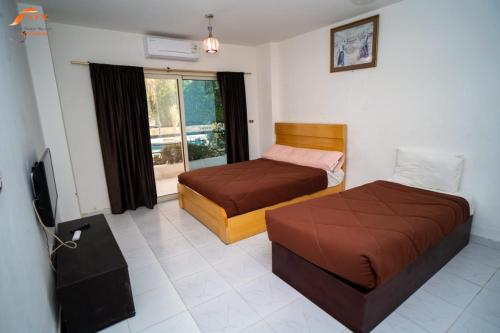 - une chambre avec 2 lits et une télévision dans l'établissement ELCAPTION RESORT, à Hurghada