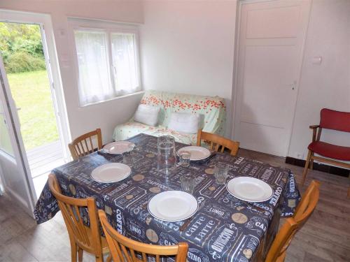 - une table à manger avec des assiettes, des chaises et un canapé dans l'établissement Meschers sur Gironde - AGREABLE MAISON au CALME - grand jardin - FORET, à Meschers-sur-Gironde