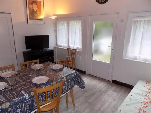 une salle à manger avec une table, des chaises et une télévision dans l'établissement Meschers sur Gironde - AGREABLE MAISON au CALME - grand jardin - FORET, à Meschers-sur-Gironde