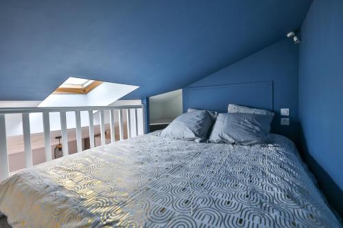 - une chambre bleue dotée d'un lit avec un mur bleu dans l'établissement Le Victor Hugo #Hypercentre #Netflix, à Cognac