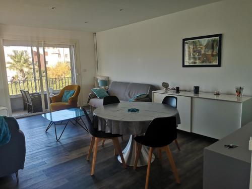 une cuisine et un salon avec une table et des chaises dans l'établissement L'Azuréou, spacieux T3 à 150m de la plage, à Six-Fours-les-Plages