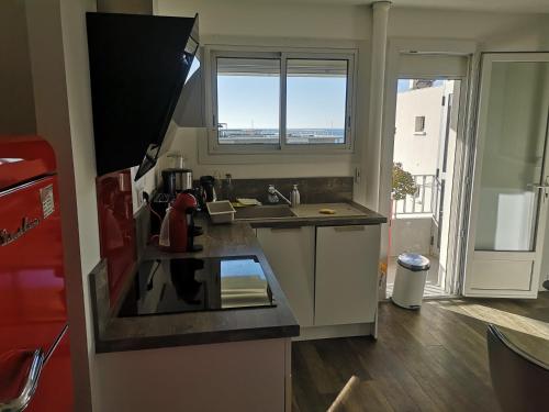 une petite cuisine avec un évier et une fenêtre dans l'établissement L'Azuréou, spacieux T3 à 150m de la plage, à Six-Fours-les-Plages