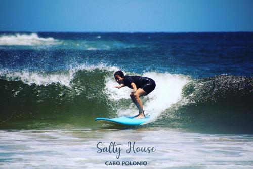 a man riding a wave on a surfboard in the ocean at Salty House Cabo Polonio in Cabo Polonio