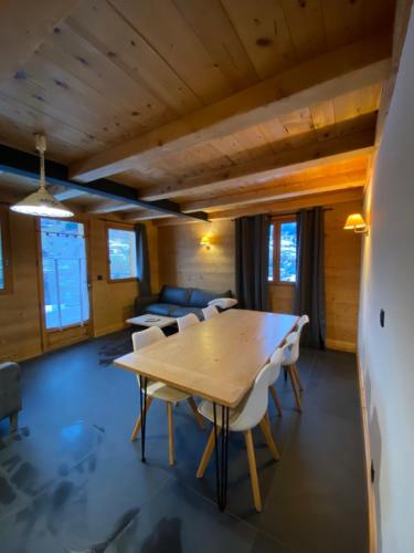 a large room with a wooden table and chairs at La Ferme des Georgières "Séjour en tout compris" in Notre-Dame-de-Bellecombe