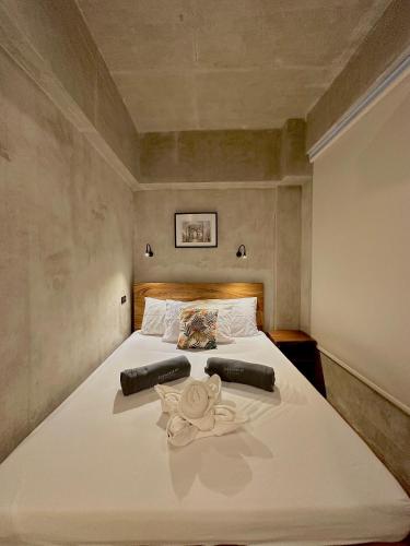 a bedroom with a large white bed with towels on it at Shorebreak Hostel San Juan La Union in san juan la union