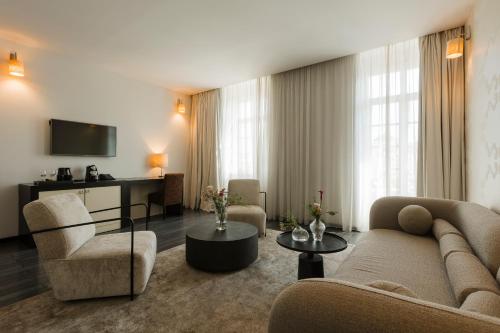 a living room with a couch and chairs and a television at Hotel Timisoara in Timişoara