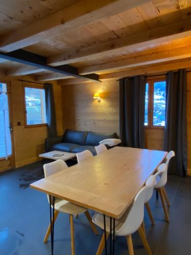 a living room with a wooden table and chairs at La Ferme des Georgières "Séjour en tout compris" in Notre-Dame-de-Bellecombe