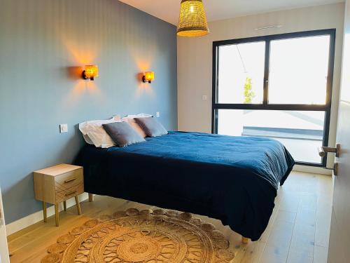 ナントにあるJolie maison neuve Nantes-Zolaの青い毛布と窓のあるベッドのある寝室