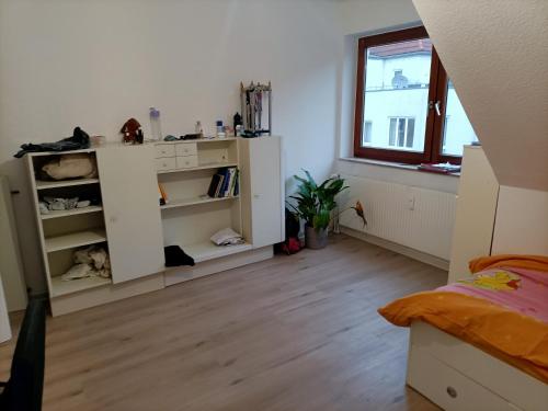 1 dormitorio con armario blanco y suelo de madera en Bahnhof, en Bielefeld