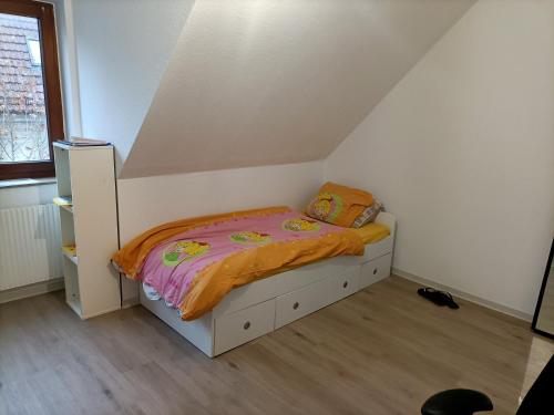 a small bedroom with a bed with an orange blanket at Bahnhof in Bielefeld