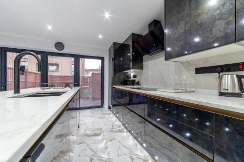 a kitchen with marble counter tops and a large window at Home from Home in London