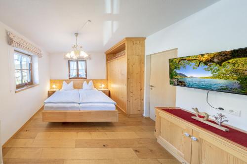 a bedroom with a bed and a tv on the wall at Gästehaus Oberland in Wallgau