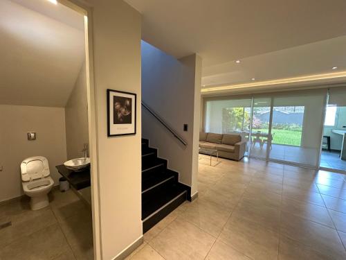 a living room with a staircase and a toilet at Casa Ceibo - Bon Repos in Yerba Buena