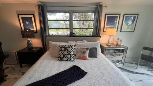 a bedroom with a bed with pillows and a window at Paradise Gardens-Wilton Manors-Clothing Optional- Male only in Fort Lauderdale