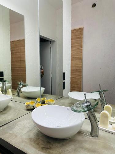 a bathroom with three sinks on a counter with a mirror at Casa Simona in Las Rabonas