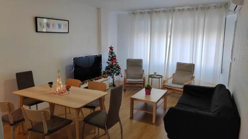 a living room with a table and chairs and a christmas tree at Apartamento Ceuta in Murcia