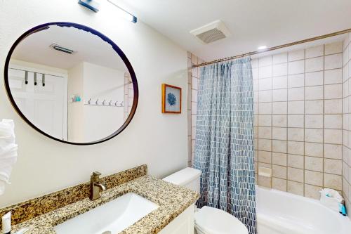 a bathroom with a sink and a toilet and a mirror at Island Princess 704 in Fort Walton Beach