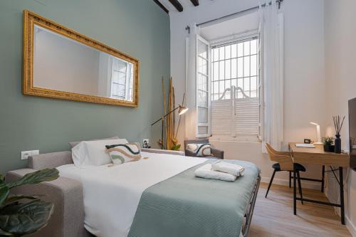 een slaapkamer met een bed, een bureau en een spiegel bij C60 Pretty loft in downtown in Málaga
