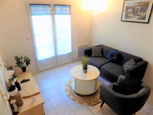 - un salon avec un canapé, des chaises et une table dans l'établissement Meschers sur Gironde - MAISONNETTE de VACANCES - terrasse - proche PLAGE, à Meschers-sur-Gironde
