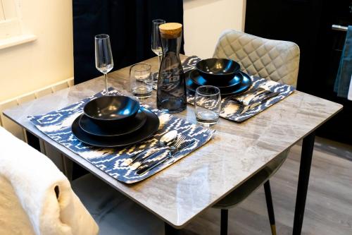 een tafel met borden en glazen en een fles wijn bij Kirkgate Suites - Signature Suite in Leeds